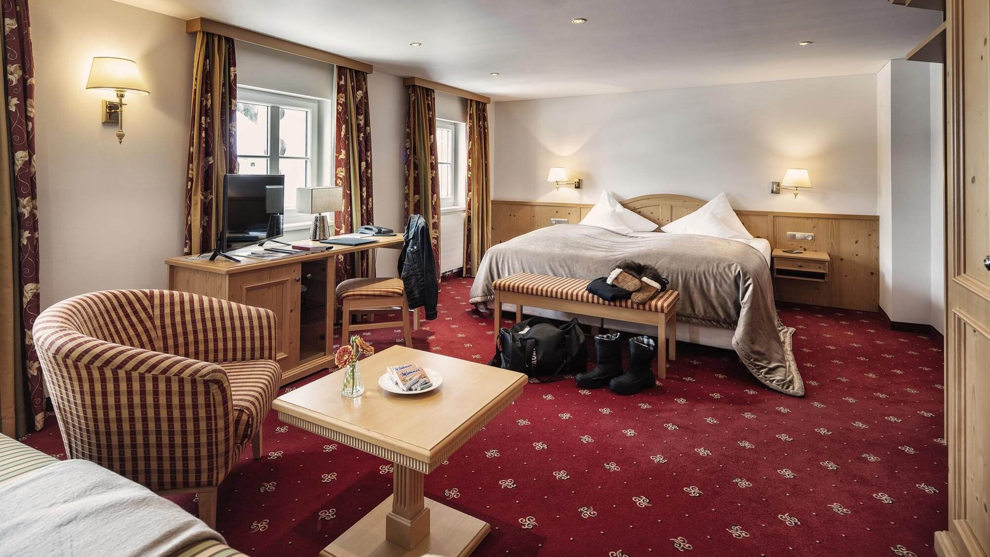 Elegante Hotelzimmer für erholsame Nächte Deluxe Doppelzimmer mit großem Bett, Sitzbereich und Schreibtisch im Arlberg Hotel