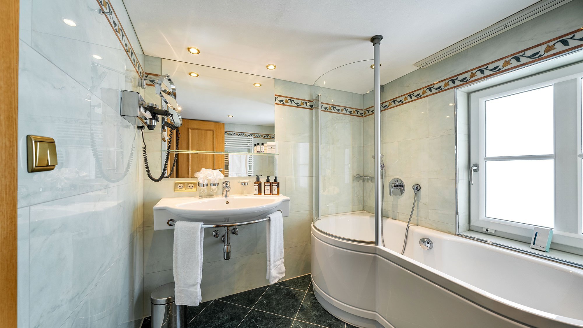 Luxuriöses Bad mit modernen Elementen Modernes Badezimmer mit geschwungener Badewanne und Duschbereich sowie zeitgemäßen Armaturen