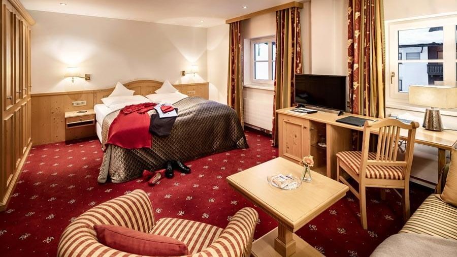 Komfortables Doppelzimmer mit eleganter Einrichtung Helles Hotelzimmer mit einem Doppelbett, einer Sitzecke und einem Schreibtisch für Entspannung und Arbeit.
