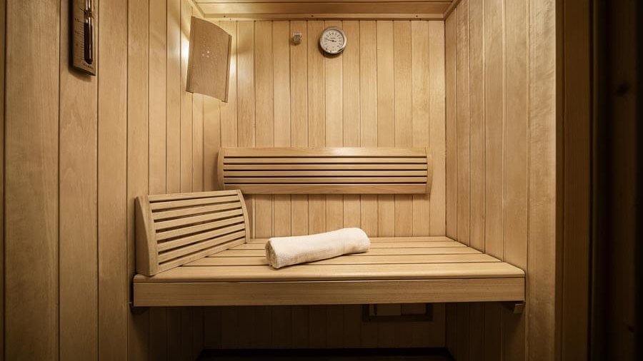 Entspannung in der Holzsauna Holzsauna mit Bänken und einer Wanduhr für entspannende Atmosphäre im Innenraum.