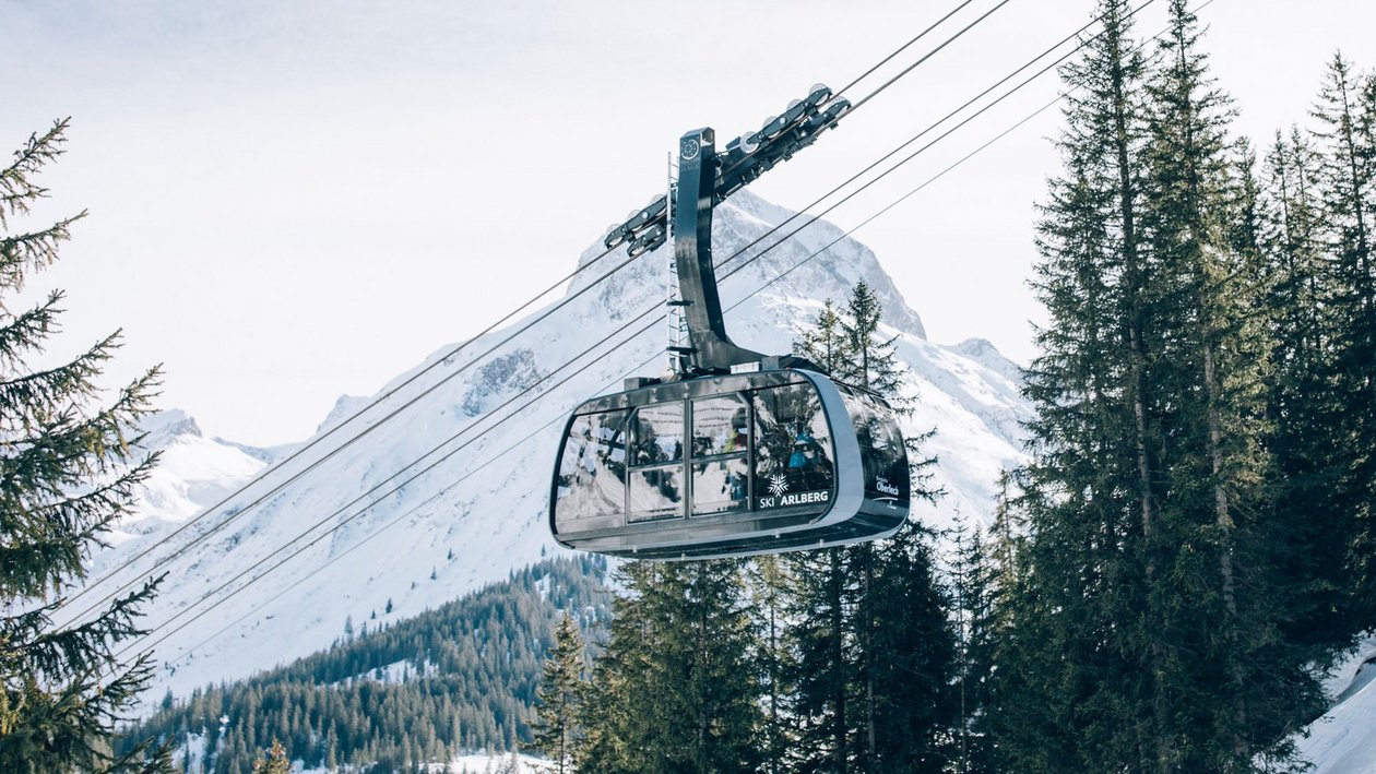 Gondelfahrt im Winterparadies Eine Gondel fährt über schneebedeckte Berge und Tannenbäume in einer winterlichen Landschaft
