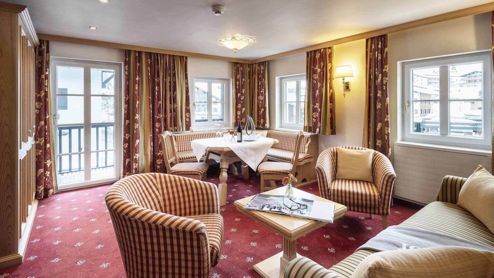 Elegante Hotelzimmergestaltung Luxuriöses Hotelzimmer mit Sitzbereich, großen Fenstern und stilvollen Vorhängen.