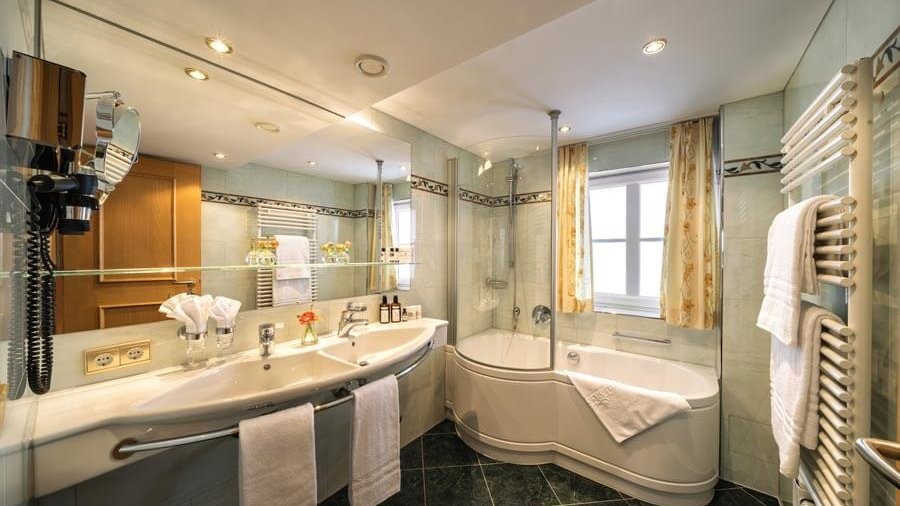 Luxuriöses Badezimmerdesign für modernes Wohnen Modernes Badezimmer mit Badewanne, Waschbecken und stilvollen Armaturen in geräumiger Umgebung