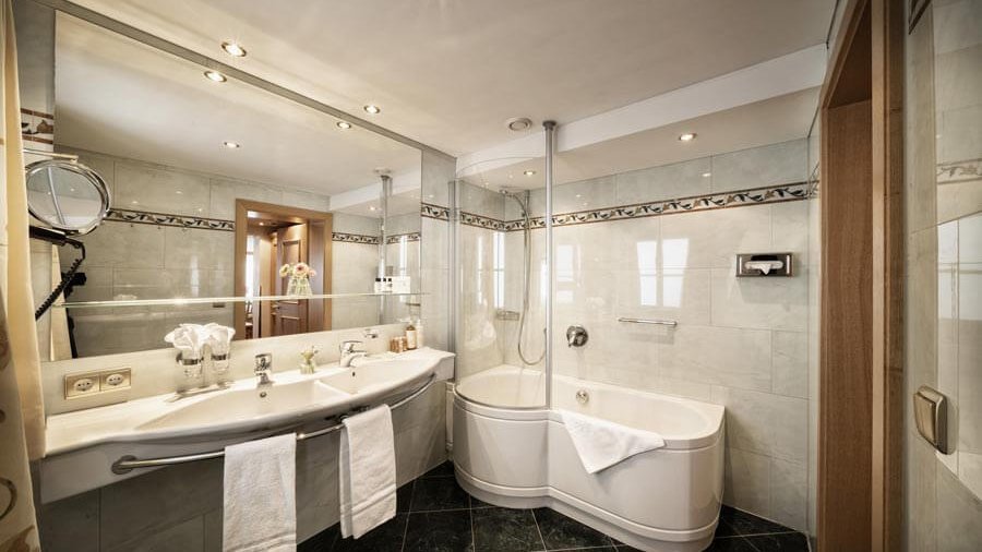 Elegantes Badezimmer im Tannbergerhof Modernes Badezimmer mit freistehender Badewanne und Doppelwaschbecken in luxuriösem Design