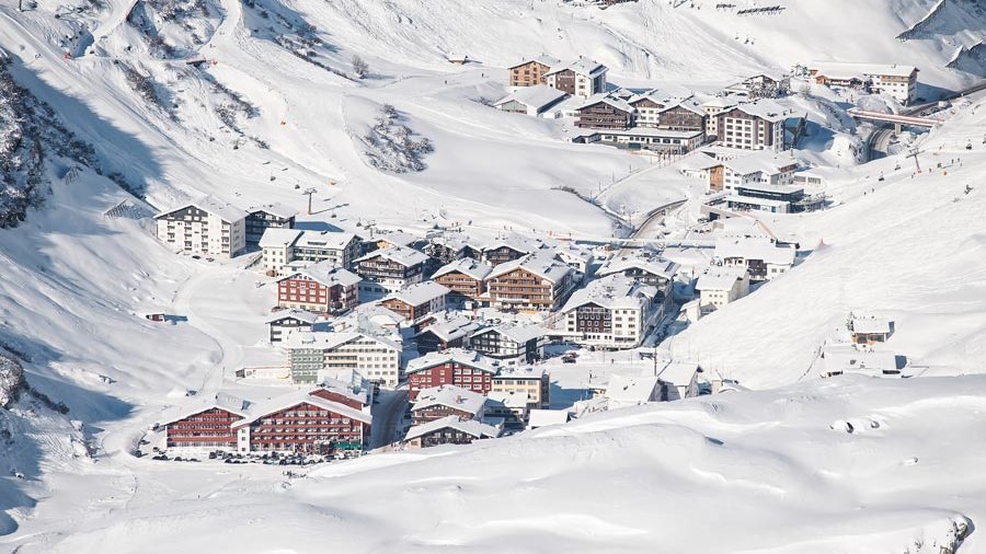 Winterliches Dorfidyll im Arlberg Schneebedeckte Gebäude in einem malerischen Dorf in den Bergen mit Winterlandschaft