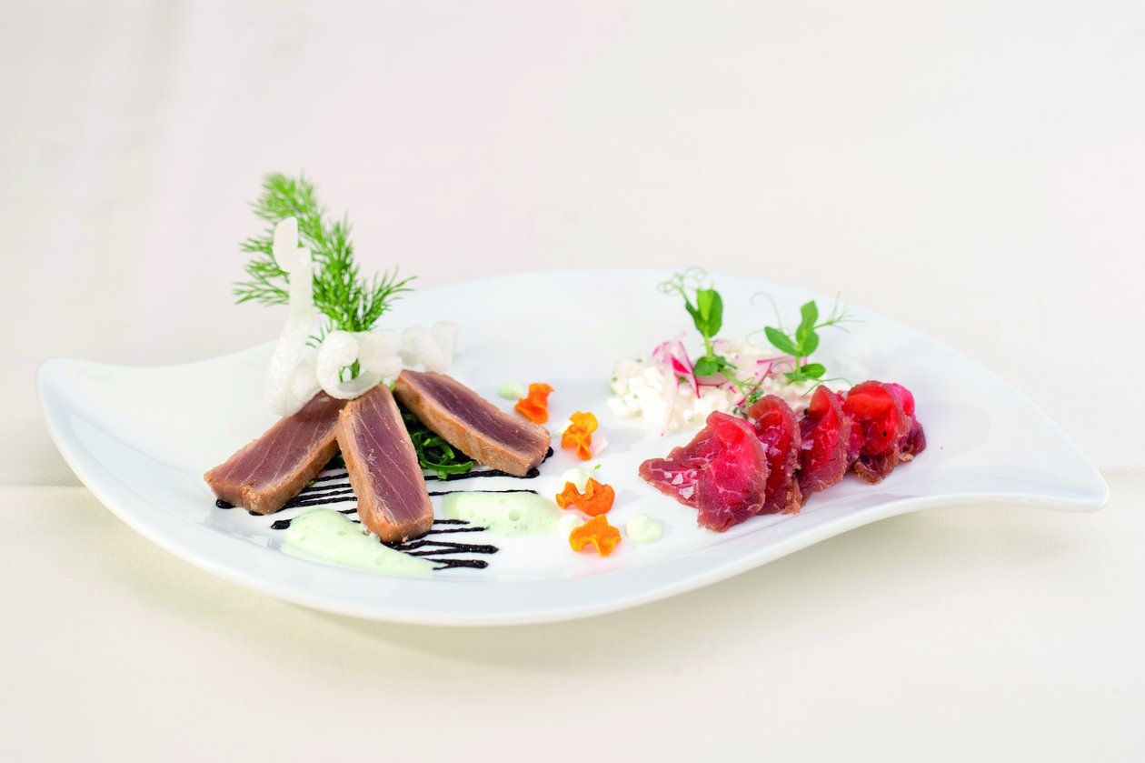 Genussvolle Momente im Restaurant in Lech Appetitlich angerichtetes Menü aus Fleisch und Fisch im Restaurant im Hotel Tannbergerhof