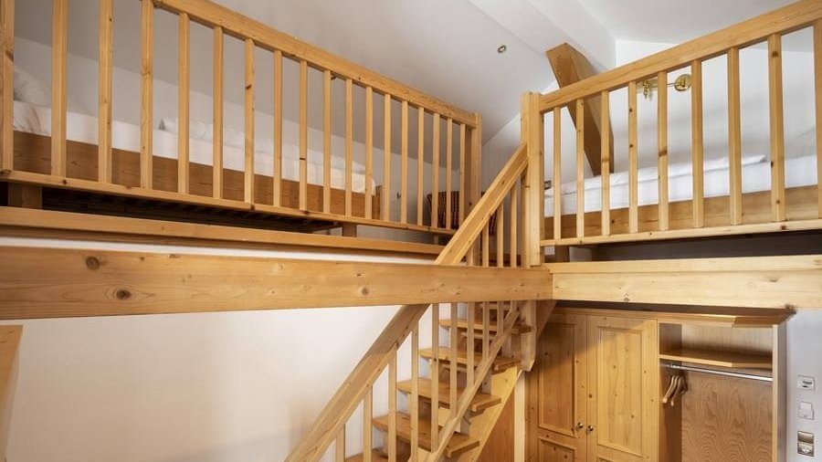 Loft Schlafzimmer mit Holztreppe Loft-Stil Schlafzimmer mit einer Holztreppe zu einem oberen Schlafbereich und minimalistischer Gestaltung