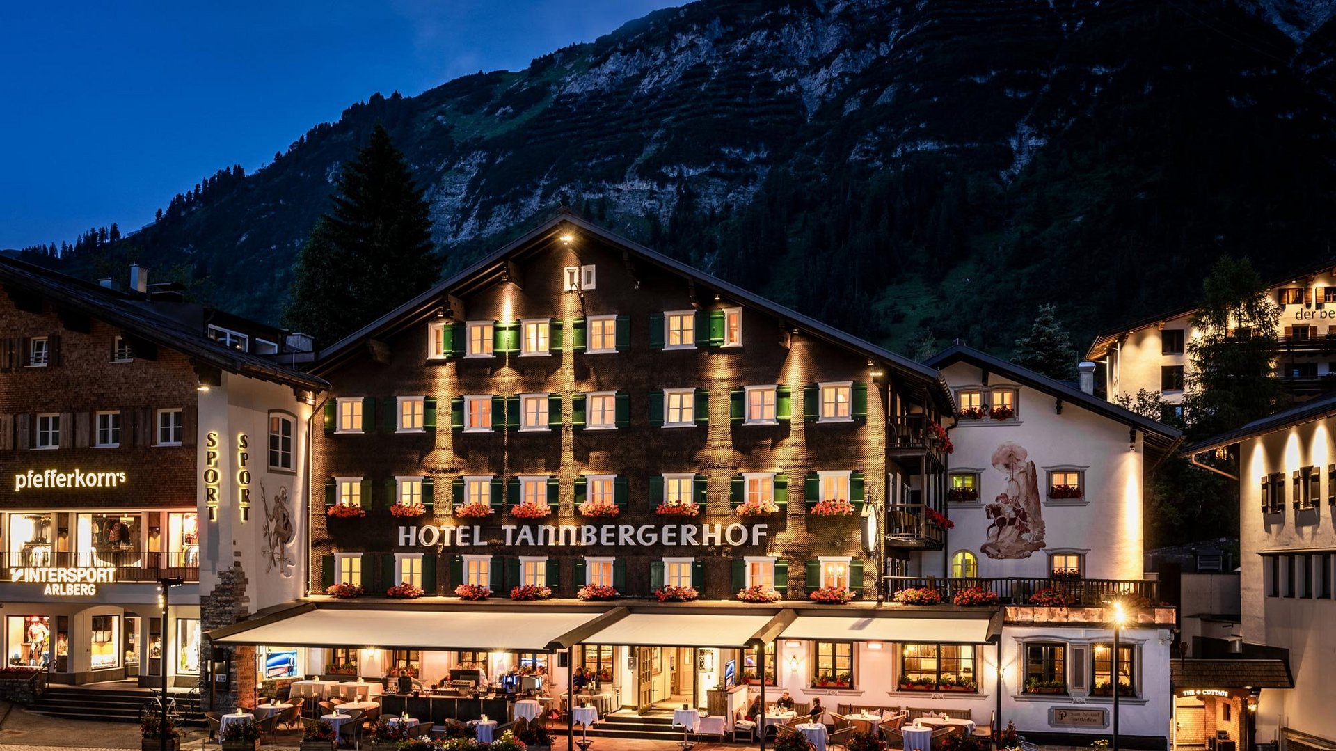 Tannbergerhof Hotel Night Illumination Hotel Tannbergerhof exterior lit up at night with mountains in the background, showcasing alpine scenery