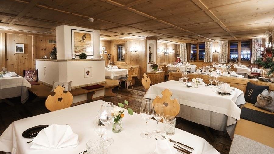 Gemütliches Restaurantambiente Restaurant Innenraum mit Holzdekor und liebevoll gedeckten Tischen in warmer Atmosphäre.