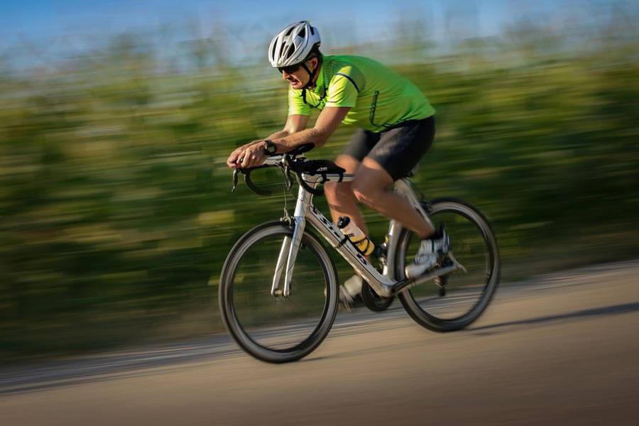 Freuen Sie sich auf Ihren Rennradurlaub in Lech Ein Rennrad Fahrer fährt eine Straße hinab neben einem Maisfeld