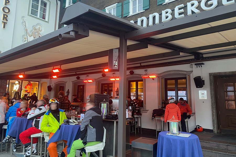 Winterliches Genussmoment im Freien Skifahrer die in der Après Ski-Bar des Tannbergerhofs sitzen