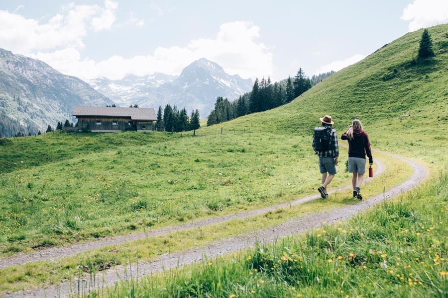 Traumhaften Natur und der schönen Bergwelt Ein Paar wandert auf einem Weg zu einer Hütte