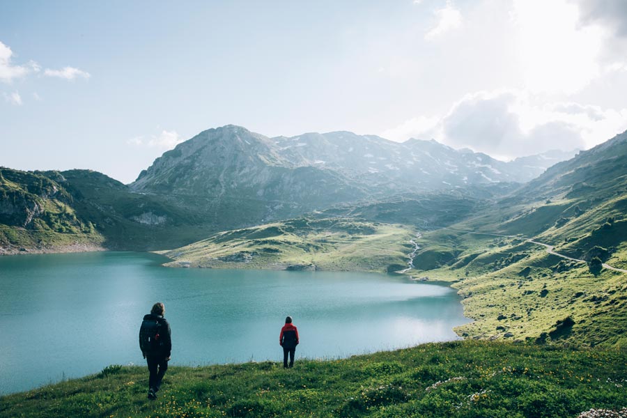 Wunderschönen natürlichen Bergsee Zwei Wanderer blicken auf einen wunderschönen natürlichen Bergsee