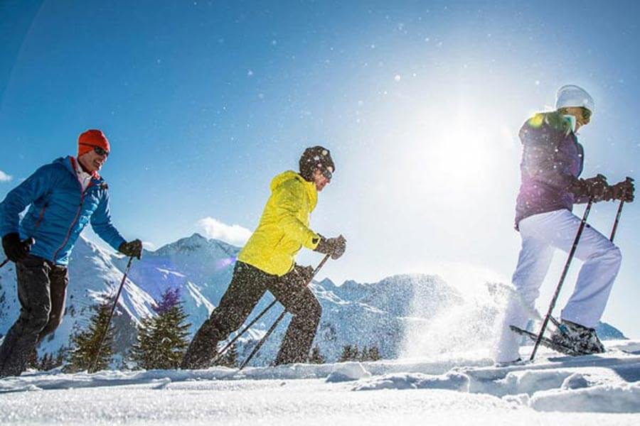 Schneeschuhwandern für Anfänger und Profis Schneeschuhwandern im strahlenden Sonnenschein und traumhaften Pulverschnee