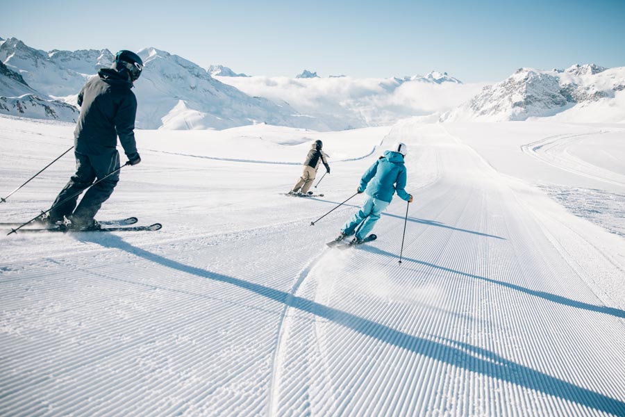 Skiurlaub in lech am Arlberg Eine Gruppe fährt eine frisch-präperierte Piste runter