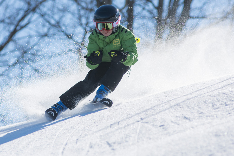 Skiurlaub in Lech am Arlberg mit der ganzen Familie Kind fährt Piste hinab