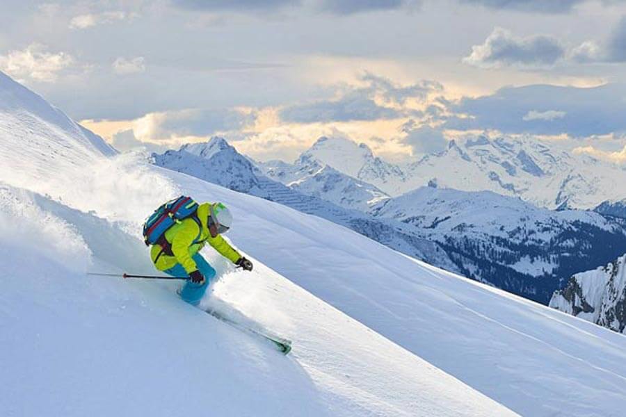 Abenteuer im Schnee auf den Pisten Ein Skifahrer in leuchtender Ausrüstung fährt eine unberührte Tiefschneeabfahrt am Arlberg hinunter