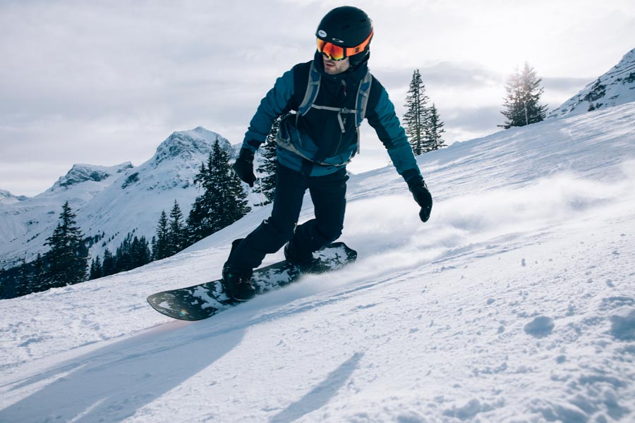 Fantastische Tricks und Obstacles im Tiefschnee Ein Snowboarder fährt die Piste hinab