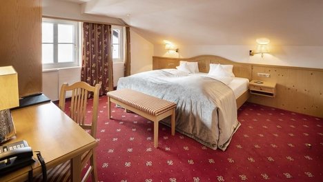Moderne Familien Juniorsuite Hotelzimmer mit Doppelbett, Schreibtisch und Sitzbereich in einem eleganten Design