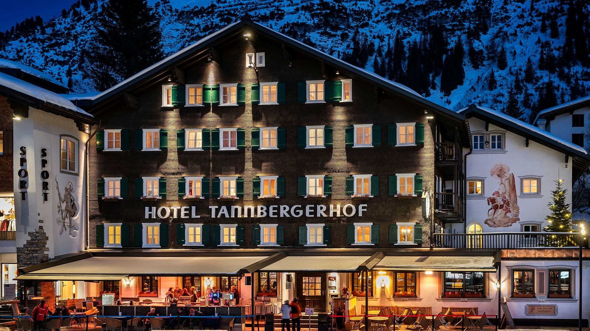 Winterzauber am Tannbergerhof Außenansicht des Hotels Tannbergerhof mit erleuchteten Fenstern und Schnee im Hintergrund
