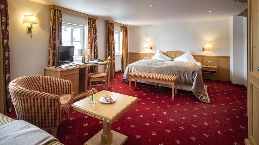 Luxuriöses Doppelzimmer für erholsame Nächte Geräumiges Hotelzimmer mit großem Bett, Sitzbereich und Schreibtisch mit Computer